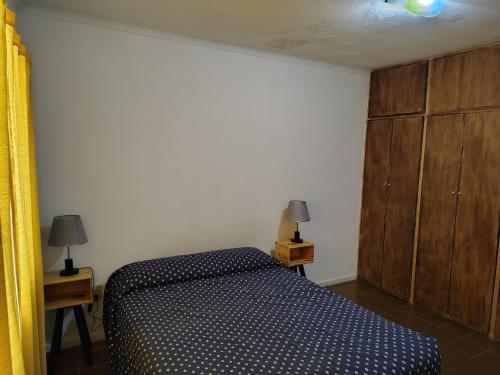 a bedroom with a bed and a wooden cabinet at Departamento Plaza España in San Rafael