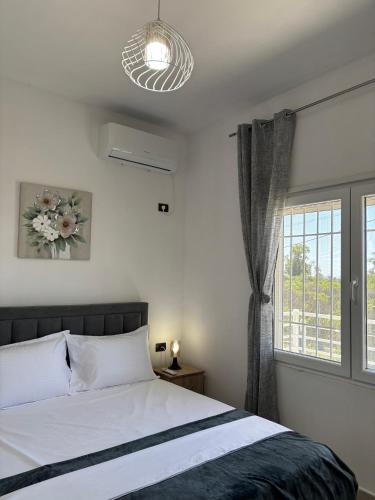 a bedroom with a bed and a large window at Villa 176 in Baks-Rrjoll