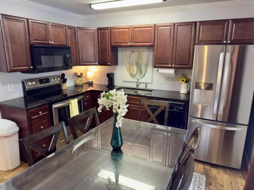 Una cocina con una mesa con un jarrón de flores encima. en Charming Townhouse Near Lake, en Guntersville