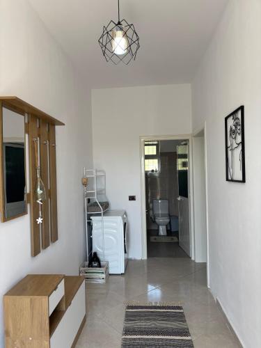 a living room with white walls and a pendant light at Villa 176 in Baks-Rrjoll