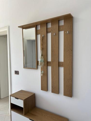 a wall with four wooden cupboards and a mirror at Villa 176 in Baks-Rrjoll