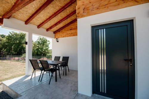 a patio with a table and chairs and a door at Sunny Apartments in Malo Laole