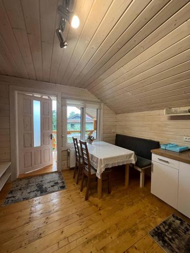 a kitchen with a table and chairs in a room at Карпатська Модрина in Kosiv