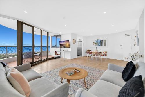 a living room with two couches and a table at Albatross North Apartments in Gold Coast
