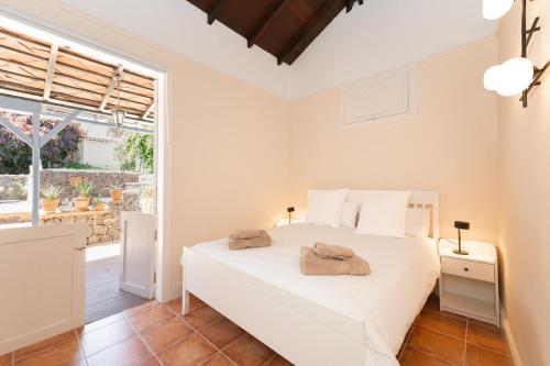 ein Schlafzimmer mit einem weißen Bett und einem großen Fenster in der Unterkunft La Casita, in the heart of Puerto De la Cruz in Puerto de la Cruz