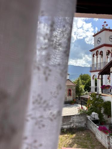 a building with a clock tower in front of it at Mountain nest B in Elati Trikalon