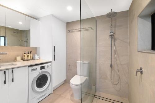 a bathroom with a toilet and a glass shower at Albatross North Apartments in Gold Coast