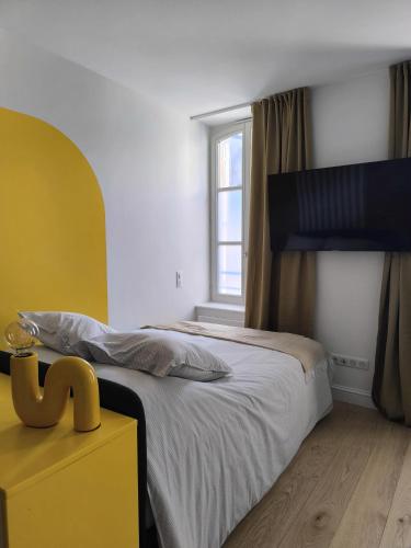 une chambre avec un grand lit et une fenêtre dans l'établissement Le Yellow - Moderne & design - Centre Metz - Wi-Fi, à Metz