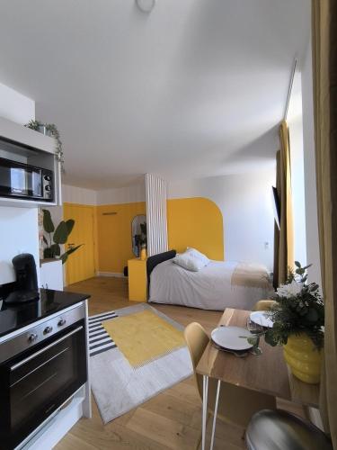 un salon avec un lit et une table dans l'établissement Le Yellow - Moderne & design - Centre Metz - Wi-Fi, à Metz