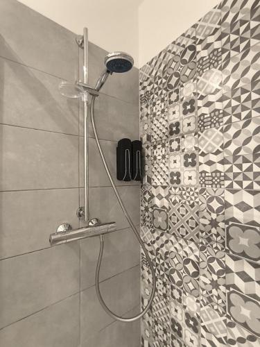 une douche dans une salle de bain avec un mur carrelé dans l'établissement Le Yellow - Moderne & design - Centre Metz - Wi-Fi, à Metz