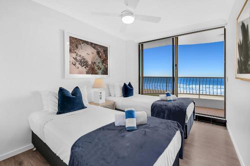 a bedroom with two beds and a large window at Albatross North Apartments in Gold Coast