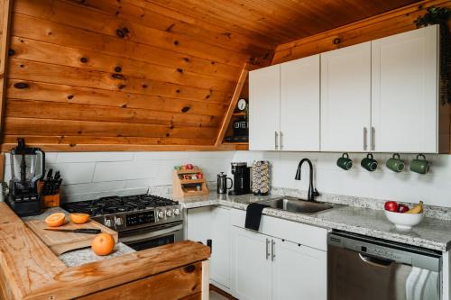 a kitchen with white cabinets and a wooden ceiling at Rustic Escape UTV, Tub, Trails & Fire Pit 25 acre in Roscoe