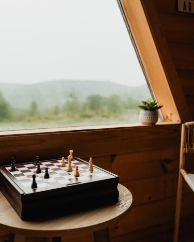 a chess board on a table in front of a window at Rustic Escape UTV, Tub, Trails & Fire Pit 25 acre in Roscoe
