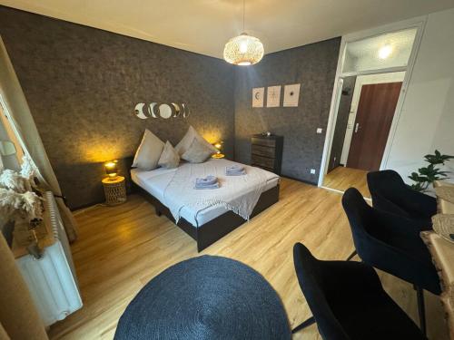 a bedroom with a bed and chairs in a room at BOHO Apartment Elegance in Bad Reichenhall