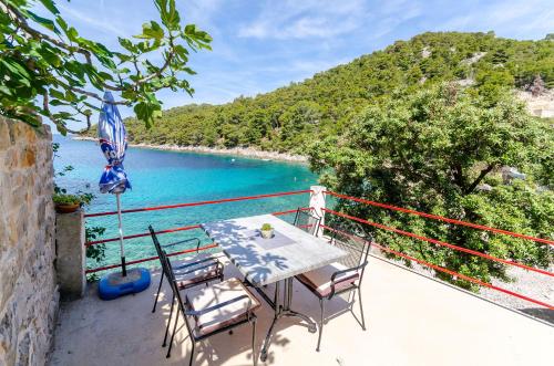 een tafel en stoelen op een balkon met uitzicht op de oceaan bij House Herta in Gdinj