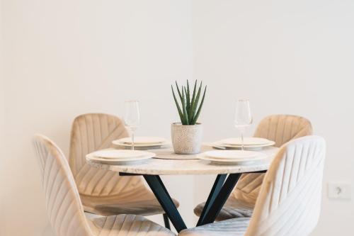 a dining room table with chairs and a plant at Dani Deluxe Apartments in Ulcinj