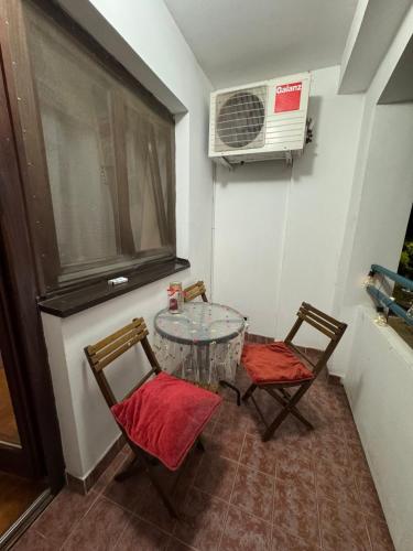 a room with a table and two chairs and a fan at Peace in the heart of downtown in Pančevo