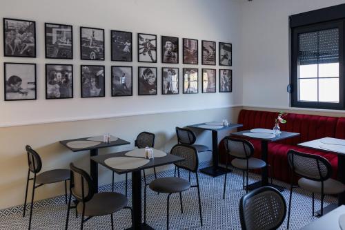 a dining room with tables and chairs and pictures on the wall at Garni Hotel Maggitti in Velika Plana