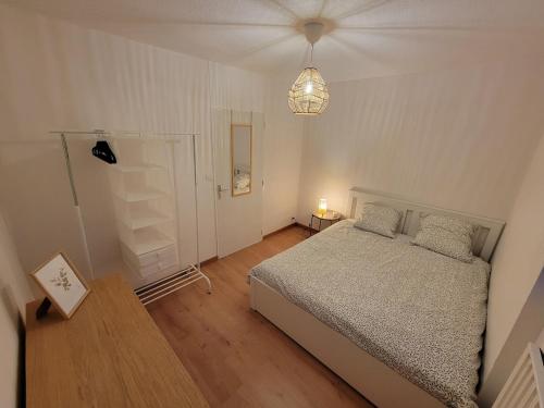 une chambre avec un lit et un lustre dans l'établissement Lumineux T3 en duplex, à Bègles