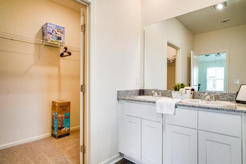 a bathroom with two sinks and a mirror at 12 Mi to Avery Island Spacious Family Home! in New Iberia