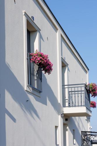 a building with two balconies with pink flowers on them at Garni Hotel Maggitti in Velika Plana