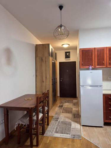 Una cocina con una mesa y un refrigerador blanco. en Stan na dan, Stari aerodrom!, en Podgorica