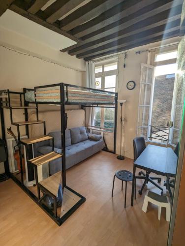 - un salon avec des lits superposés et un bureau dans l'établissement Charmant studio calme et lumineux à Notre-Dame, à Paris
