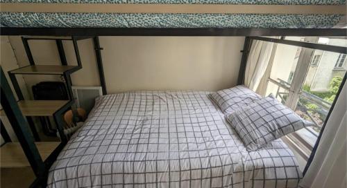 une petite chambre avec un lit et une fenêtre dans l'établissement Charmant studio calme et lumineux à Notre-Dame, à Paris