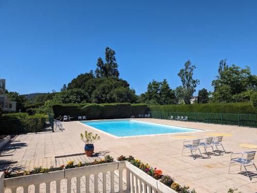 una piscina con sedie e recinzione intorno ad essa di L'Orée du Golf a Mandelieu La Napoule
