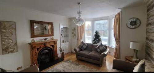 a living room with a couch and a fireplace at 4 Private bedroom house with 3 parking spaces free in Perth