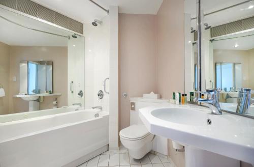 a white bathroom with a tub and a toilet and a sink at Orida Maidstone in Maidstone