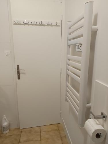 La salle de bains est pourvue d'une porte blanche et de toilettes. dans l'établissement Cosy Arles, à Arles
