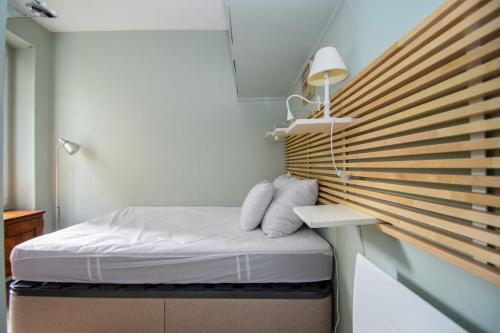 une petite chambre avec un lit et un store en bois dans l'établissement Buffon CI- Charming apartment with gardens of plants, à Paris