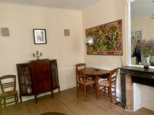 un salon avec une table et des chaises dans l'établissement Buffon CI- Charming apartment with gardens of plants, à Paris