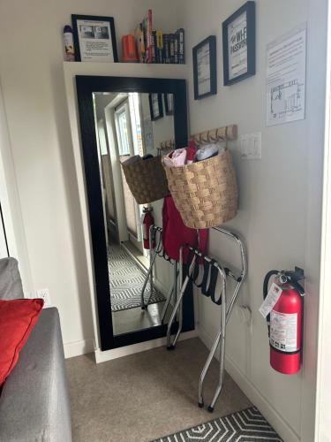 a mirror with a basket and a fire extinguisher at K STREET CARRIAGE HOUSE Studio in Penticton