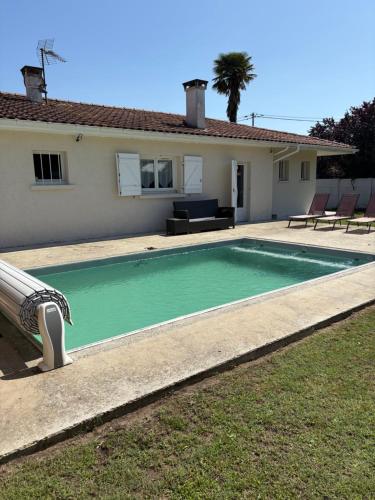 une piscine devant une maison dans l'établissement Maison 3 chambres piscine, à Saint-Vincent-de-Tyrosse