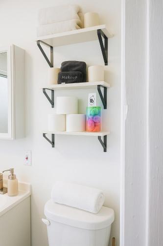 a bathroom with white shelves above a toilet at Spacious 4BR near NYC with Parking, 10min MetLife, 20min Times Sq in North Bergen