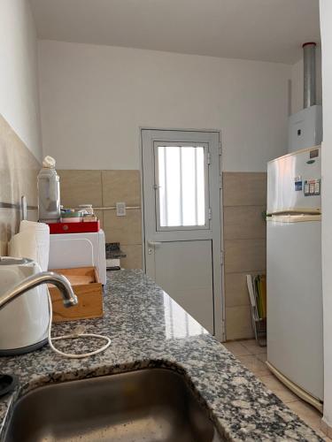 una cocina con fregadero y refrigerador en Casa 2 Habitaciones, en Las Varillas