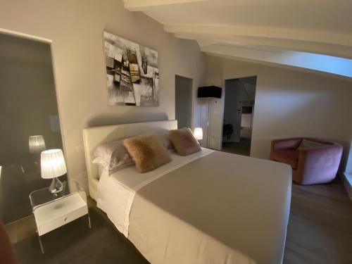 a bedroom with a white bed with two pillows on it at Le Cadran Solaire - Nel cuore di Aosta in Aosta