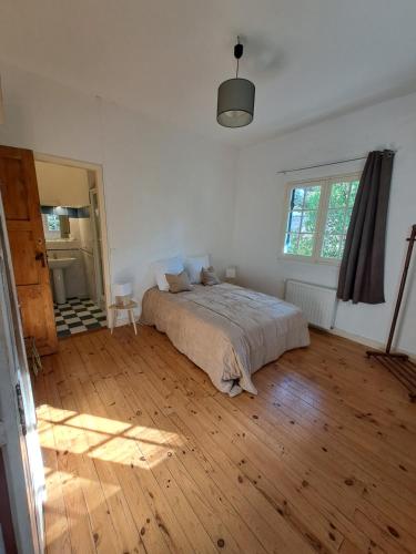 une chambre avec un lit et un parquet dans l'établissement Maison typique Pyla proche plage, à La Teste-de-Buch