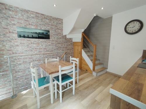 une salle à manger avec une table et des chaises et un escalier dans l'établissement Gîte LE BIVOUAC, à Fécamp