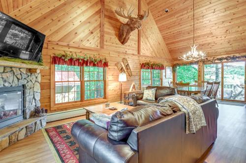 a living room with a leather couch and a fireplace at Gore Mountain Cabin Game Room and Fire Pit in North Creek