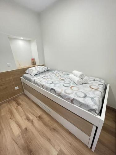 a white bed in a room with a mirror at Casa Ferreira em Fátima in Fátima