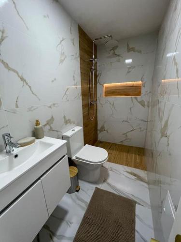 a white bathroom with a toilet and a sink at Casa Ferreira em Fátima in Fátima