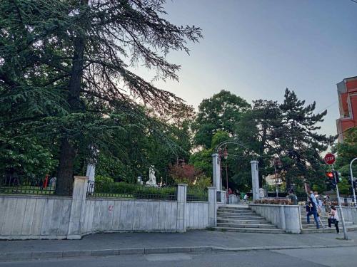 a park with stairs and a fence and trees at ParkSide Apartman in Arandjelovac