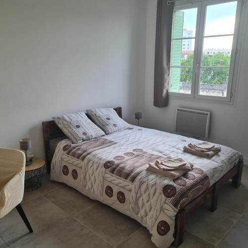 une chambre avec un lit et une fenêtre dans l'établissement Appartement Climatisé Nîmes, à Nîmes