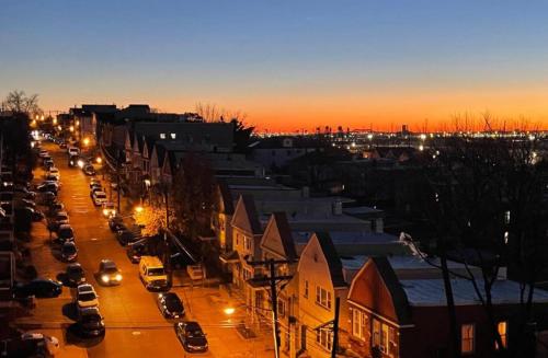 a city street at sunset with cars parked on the street at Spacious 4BR near NYC with Parking, 10min MetLife, 20min Times Sq in North Bergen