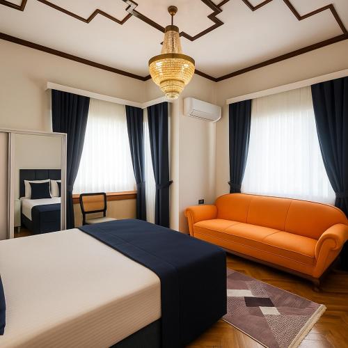 a bedroom with an orange bed and a couch at Palm Villa Büyükada in Istanbul