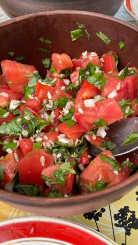 a pan filled with a salad with tomatoes and other vegetables at Faina Garna Hata in Medvin