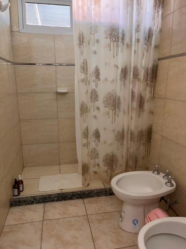Un baño con cortina de ducha y un inodoro. en Casa 2 Habitaciones, en Las Varillas